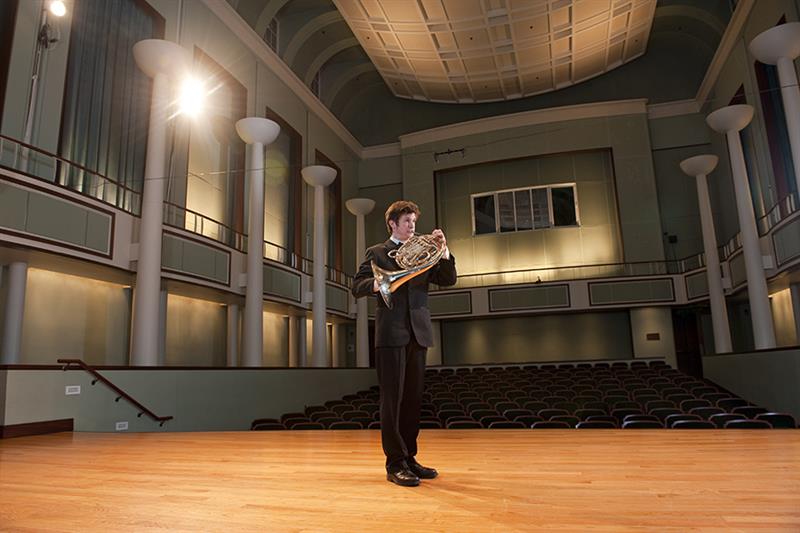 student playing horn in gore recital hall