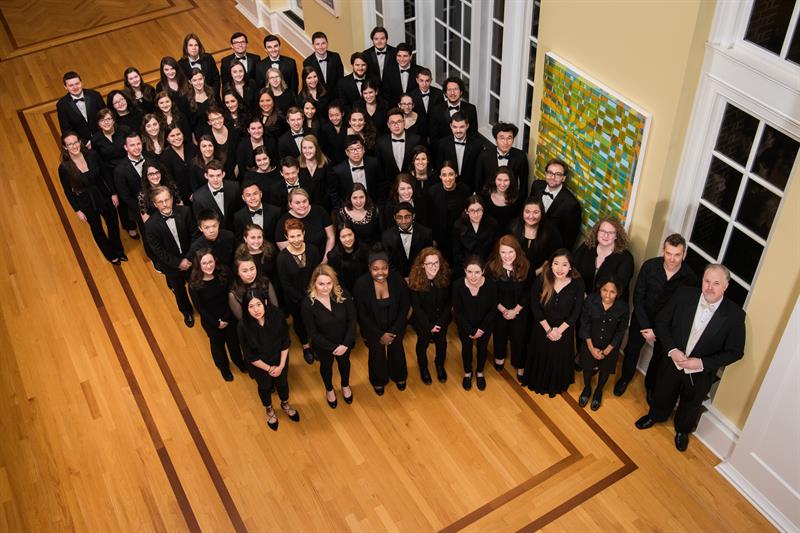 the ud orchestra standing in the lobby of the center for the arts