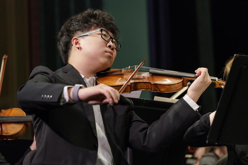 A student plays the violin. 