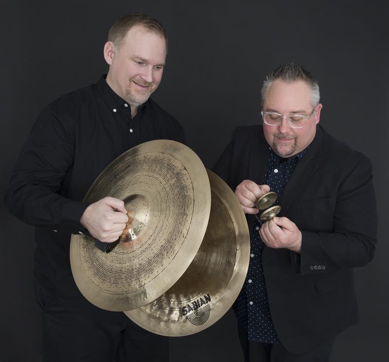 a man holding large cymbals and a man holding small cymbals
